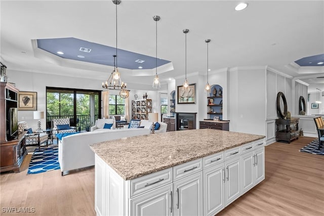 8756 Bellano Ct Unit 201, Naples, FL 34119 - kitchen featuring a tray ceiling, light wood-type flooring, open floor plan, recessed lighting, and a center island