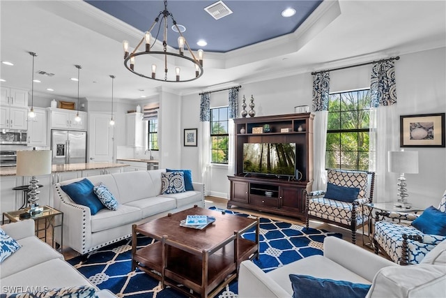 living room featuring visible vents, plenty of natural light, and ornamental molding