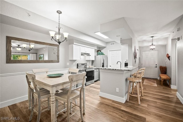 4665 Saint Croix Ln Unit 1525, Naples, FL 34109 - dining space with visible vents, baseboards, a chandelier, and wood finished floors