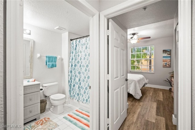 4665 Saint Croix Ln Unit 1525, Naples, FL 34109 - ensuite bathroom with vanity, visible vents, a textured ceiling, and ceiling fan