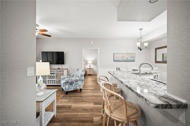 4665 Saint Croix Ln Unit 1525, Naples, FL 34109 - interior space featuring a textured wall, ceiling fan with notable chandelier, and wood finished floors