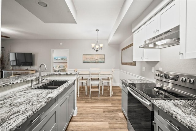 4665 Saint Croix Ln Unit 1525, Naples, FL 34109 - kitchen featuring a sink, a chandelier, stainless steel range with electric cooktop, light wood-style flooring, and under cabinet range hood
