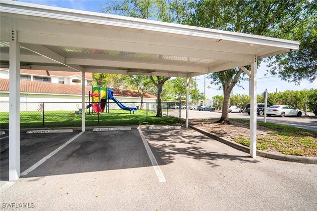 4665 Saint Croix Ln Unit 1525, Naples, FL 34109 - partially covered parking lot with playground community and fence