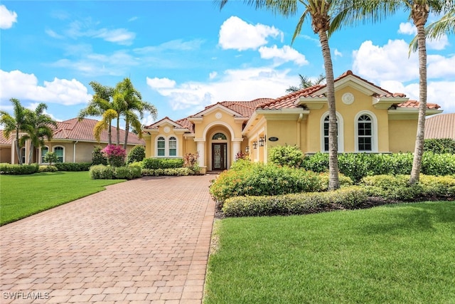 9337 Campanile Cir, Naples, FL 34114 - mediterranean / spanish house featuring a tile roof, decorative driveway, stucco siding, and a front lawn