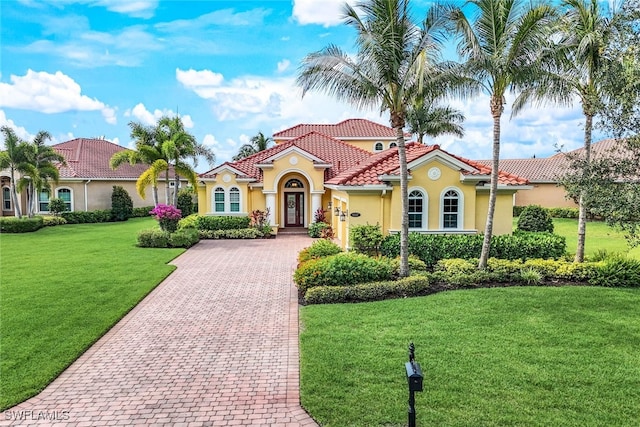 9337 Campanile Cir, Naples, FL 34114 - mediterranean / spanish-style home with decorative driveway, a tile roof, stucco siding, and a front yard