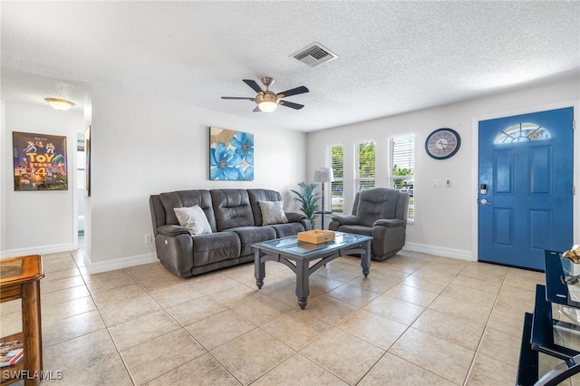 1015 SE 25th Ln, Cape Coral, FL 33904 - living room featuring a ceiling fan, a textured ceiling, light tile patterned floors, baseboards, and visible vents