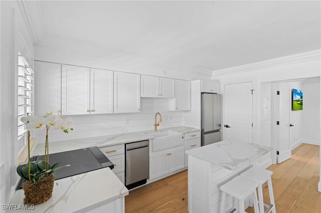980 7th Ave S Unit 107, Naples, FL 34102 - kitchen with stainless steel dishwasher, high end fridge, crown molding, white cabinetry, and light stone countertops