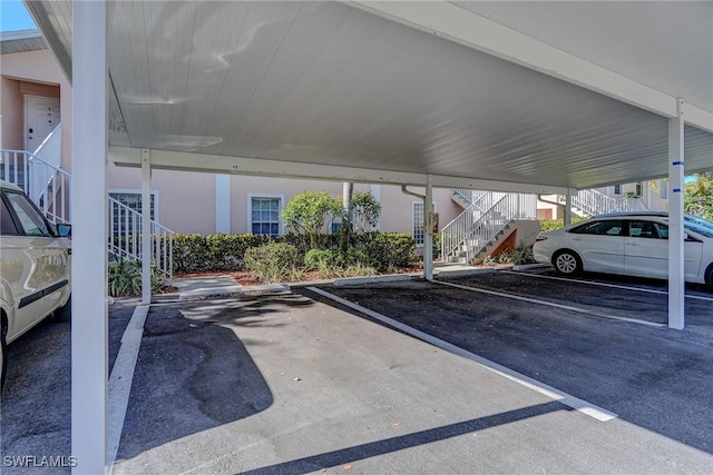 covered parking lot featuring stairway