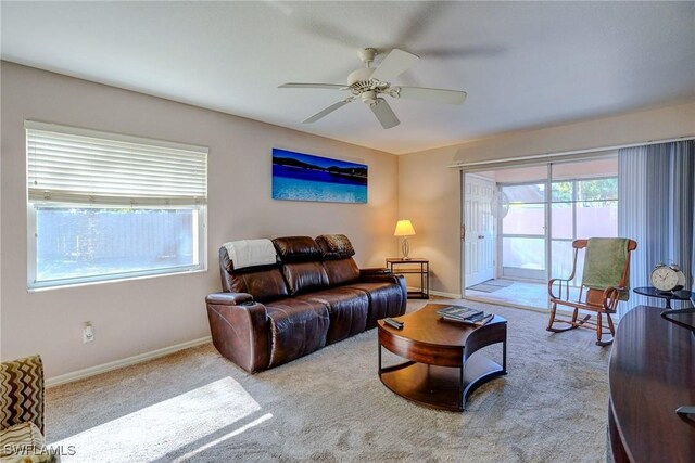 living room with baseboards, a ceiling fan, carpet flooring, and a wealth of natural light