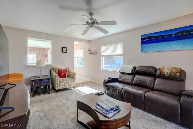 carpeted living room featuring a wealth of natural light, a ceiling fan, and baseboards