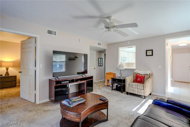 living area with visible vents, carpet floors, and ceiling fan