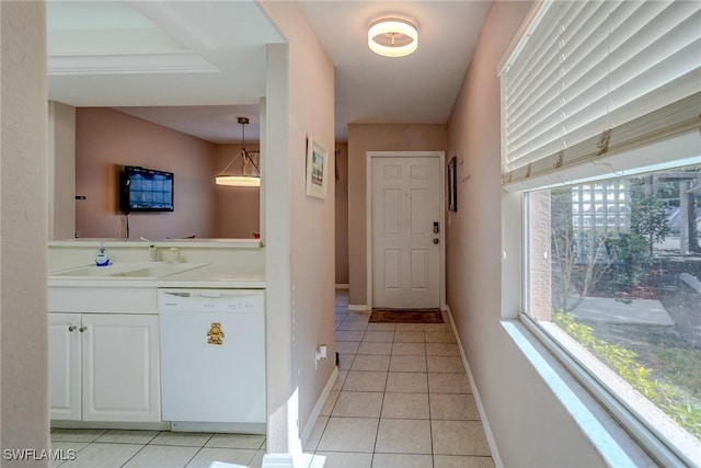 interior space with baseboards, a sink, and light tile patterned floors