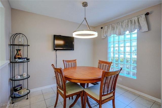 dining room featuring baseboards, light tile patterned flooring, and a healthy amount of sunlight