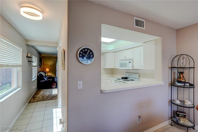 corridor featuring baseboards, visible vents, and light tile patterned floors