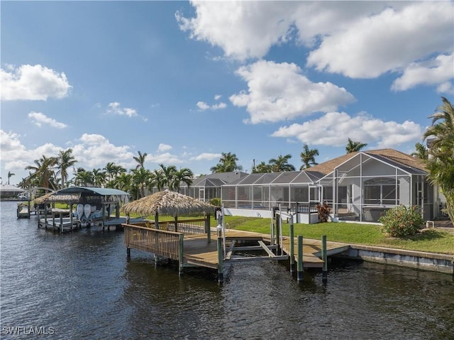 dock area with a water view, glass enclosure, and boat lift