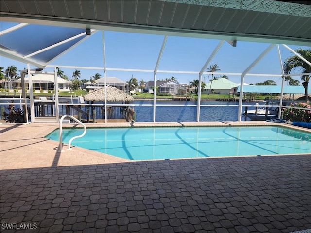pool with a lanai, a patio area, a residential view, and a water view