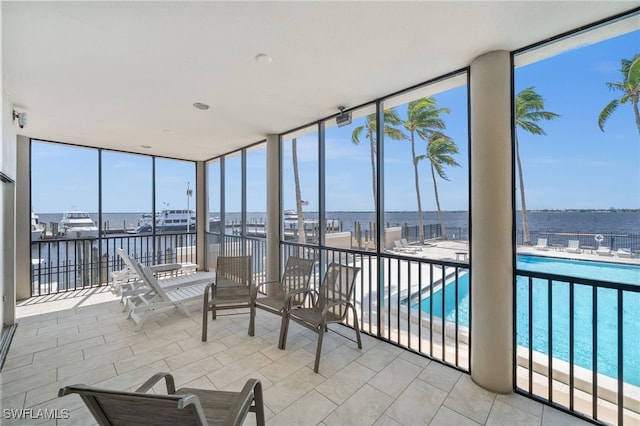 sunroom featuring a water view, expansive windows, and plenty of natural light