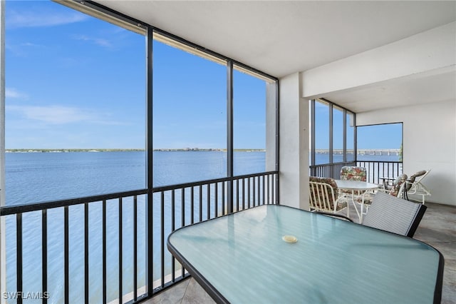 sunroom featuring floor to ceiling windows and a water view