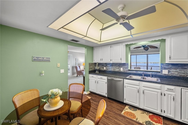 kitchen with stainless steel dishwasher, a ceiling fan, visible vents, a sink, and dark countertops