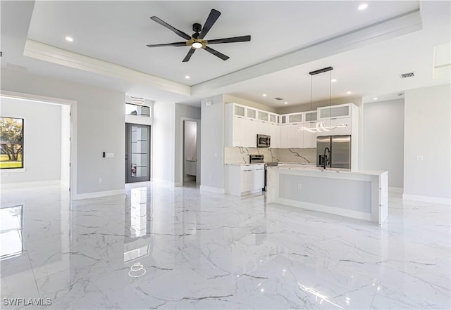 157 Everglades Blvd S, Naples, FL 34117 - unfurnished living room with a tray ceiling, recessed lighting, a ceiling fan, and light marble finish flooring