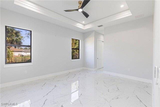 157 Everglades Blvd S, Naples, FL 34117 - unfurnished room with plenty of natural light, marble tiled floors, recessed lighting, a ceiling fan, and a tray ceiling