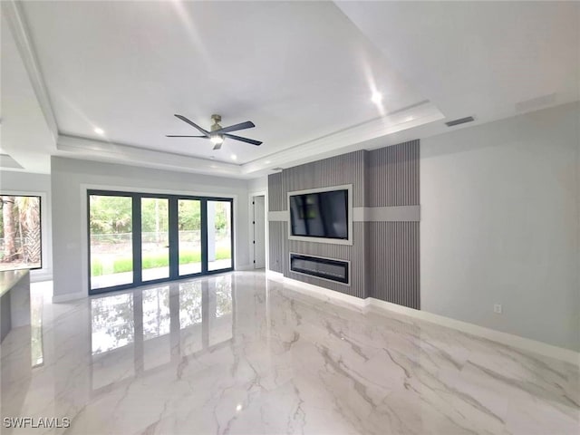 157 Everglades Blvd S, Naples, FL 34117 - unfurnished living room featuring a tray ceiling, marble tiled floors, ceiling fan, a large fireplace, and recessed lighting