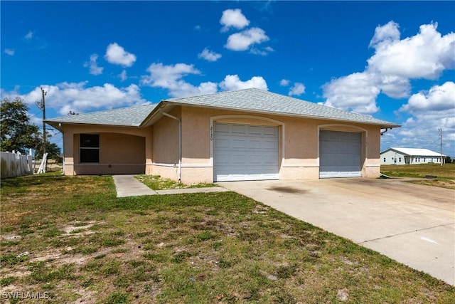 view of front facade with a front yard, stucco siding, fence, and roof with shingles