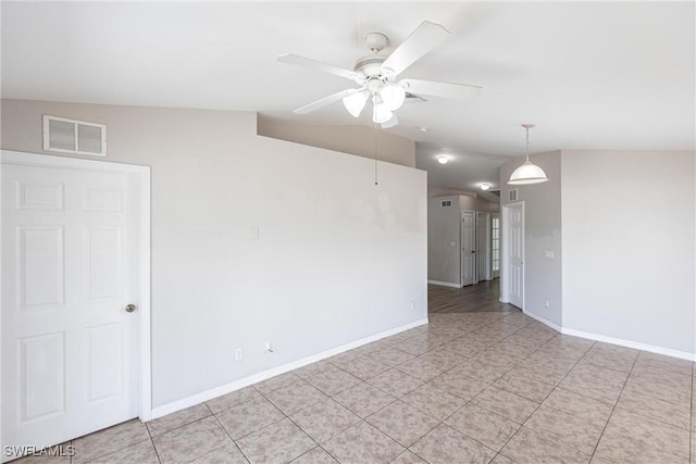 empty room with baseboards, visible vents, lofted ceiling, and a ceiling fan