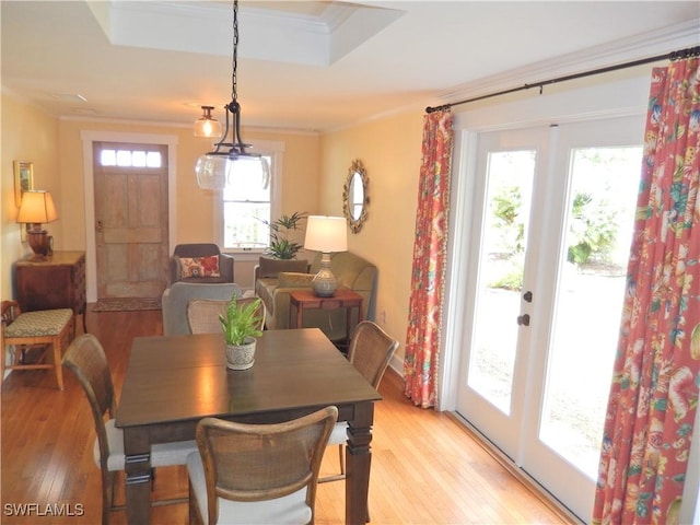dining area featuring light wood-type flooring, crown molding, and plenty of natural light