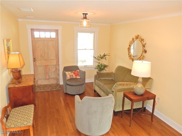 sitting room with crown molding, baseboards, and wood finished floors