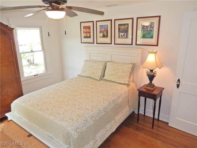 bedroom featuring visible vents, ceiling fan, and wood finished floors