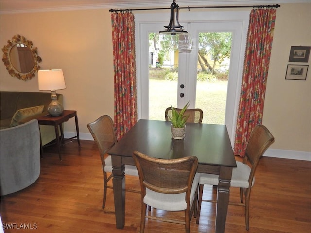 dining room with baseboards, crown molding, and wood finished floors