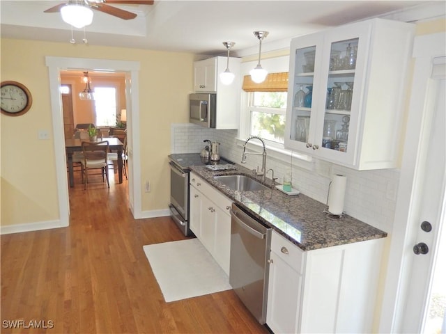 kitchen with white cabinets, stainless steel appliances, a healthy amount of sunlight, and a sink