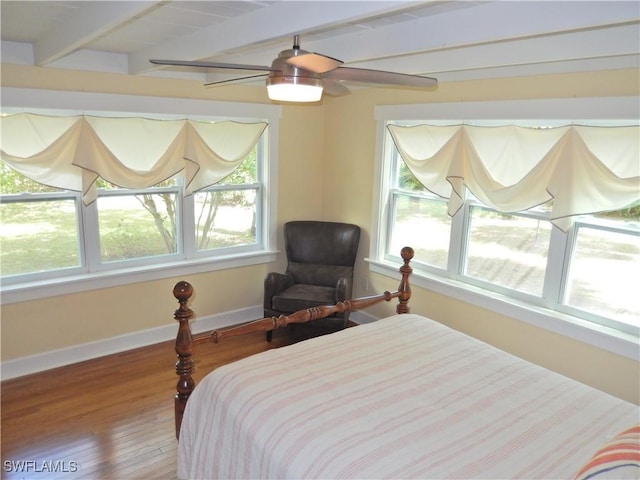 bedroom featuring hardwood / wood-style floors, baseboards, ceiling fan, and beam ceiling