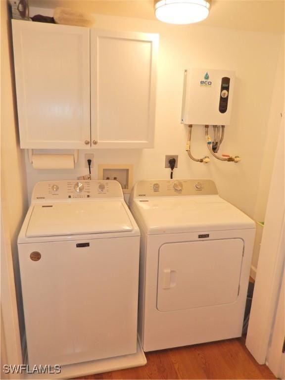 laundry room featuring cabinet space, washer and clothes dryer, and wood finished floors