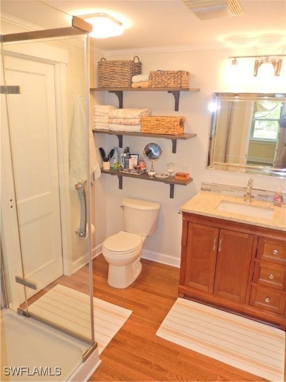 full bathroom featuring vanity, toilet, baseboards, wood finished floors, and a stall shower