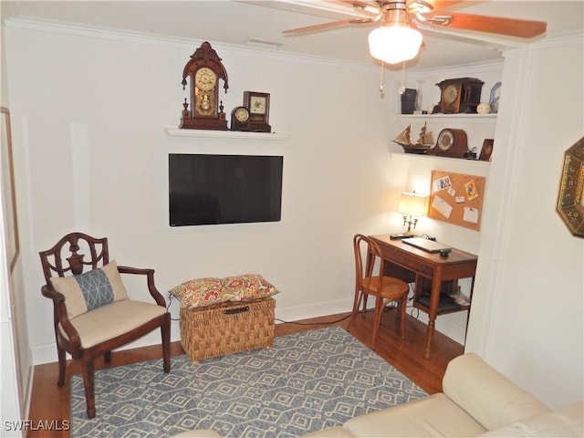 living room featuring visible vents, ornamental molding, wood finished floors, baseboards, and a ceiling fan
