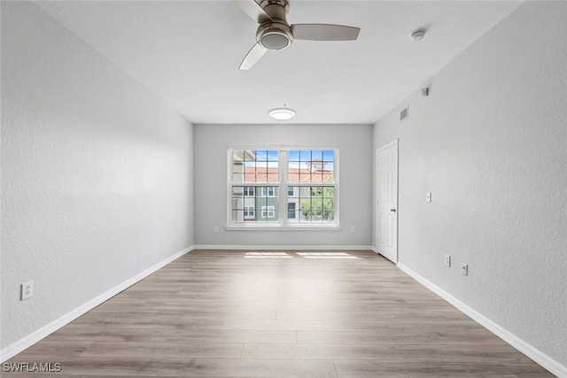 23560 Walden Center Dr Unit 306, Estero, FL 34134 - empty room with a ceiling fan, wood finished floors, a textured wall, baseboards, and a smoke detector