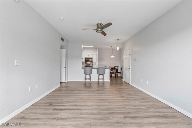 23560 Walden Center Dr Unit 306, Estero, FL 34134 - living area with a ceiling fan, light wood-type flooring, and baseboards