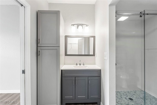 bathroom with a stall shower, wood finished floors, and vanity