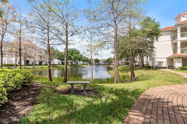 view of community featuring a water view, a yard, and a residential view