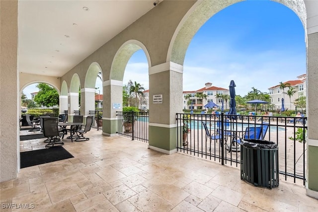 view of patio featuring a community pool and fence