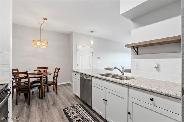 kitchen with light wood finished floors, a sink, stainless steel appliances, and tasteful backsplash