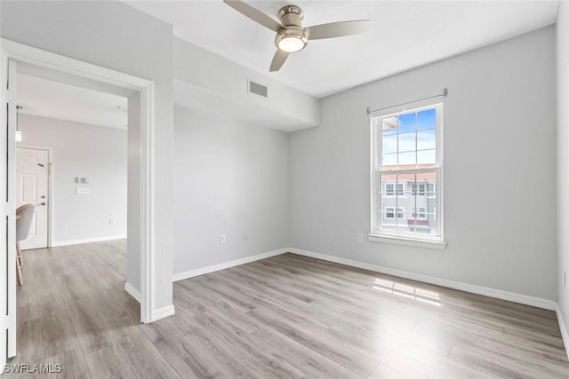 unfurnished room with light wood-style flooring, baseboards, ceiling fan, and visible vents