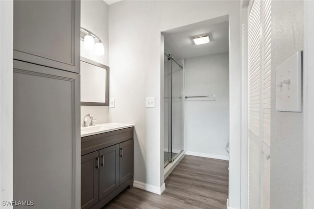 full bath with vanity, toilet, baseboards, a shower stall, and wood finished floors