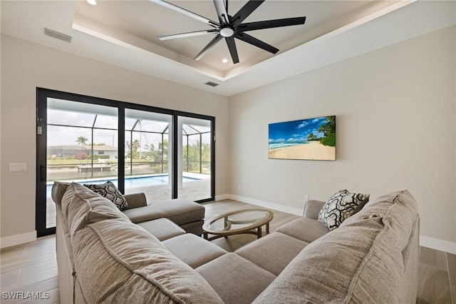 309 SW 15th Ter, Cape Coral, FL 33991 - living room featuring baseboards, visible vents, light wood-style flooring, and a raised ceiling