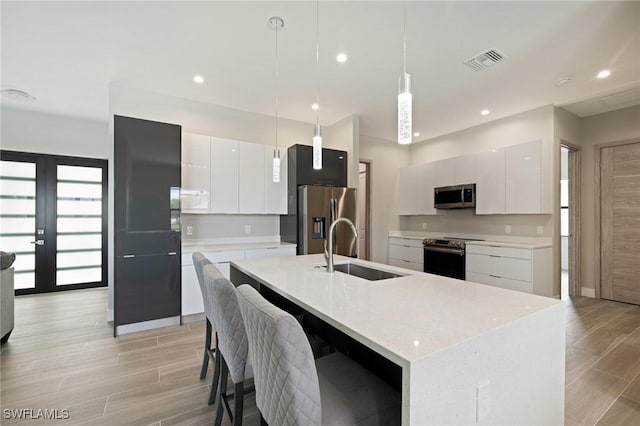 309 SW 15th Ter, Cape Coral, FL 33991 - kitchen with light countertops, a sink, modern cabinets, stainless steel appliances, and visible vents