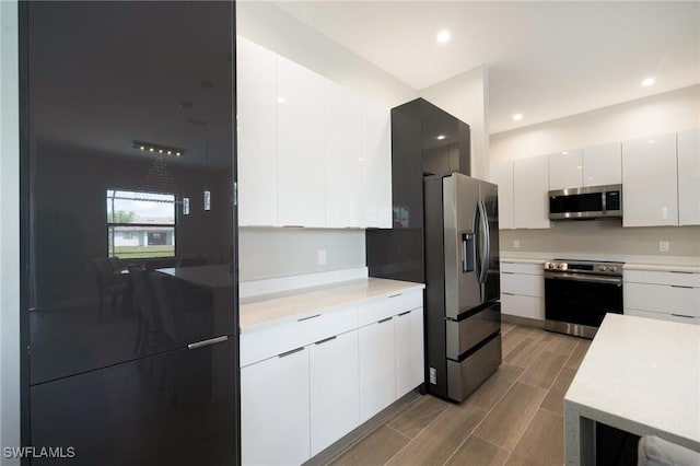 309 SW 15th Ter, Cape Coral, FL 33991 - kitchen with modern cabinets, white cabinetry, light countertops, and appliances with stainless steel finishes