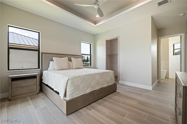 309 SW 15th Ter, Cape Coral, FL 33991 - bedroom with visible vents, baseboards, ceiling fan, wood tiled floor, and a tray ceiling