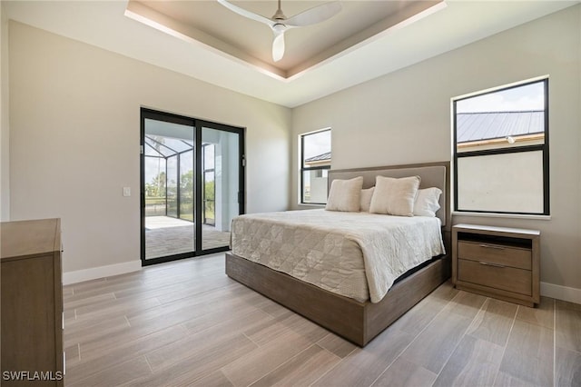 309 SW 15th Ter, Cape Coral, FL 33991 - bedroom featuring access to exterior, a raised ceiling, light wood-type flooring, baseboards, and ceiling fan